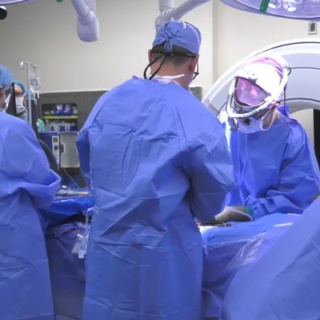 Three surgeons operating on a patient