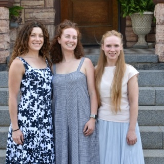 Group photo of three OBGYN residents standing outdoors. 
